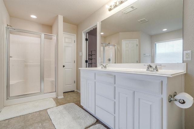 bathroom featuring an enclosed shower, vanity, a textured ceiling, and tile patterned floors