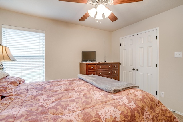 carpeted bedroom with ceiling fan and a closet