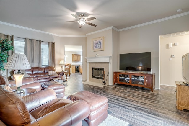 living room with a fireplace, hardwood / wood-style flooring, ceiling fan, and crown molding