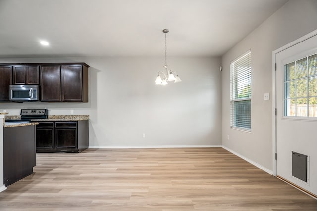 kitchen featuring light wood-type flooring, dark brown cabinets, a notable chandelier, pendant lighting, and electric range