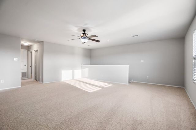 empty room with ceiling fan, light carpet, and a healthy amount of sunlight