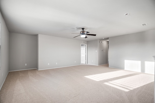 spare room featuring light carpet and ceiling fan