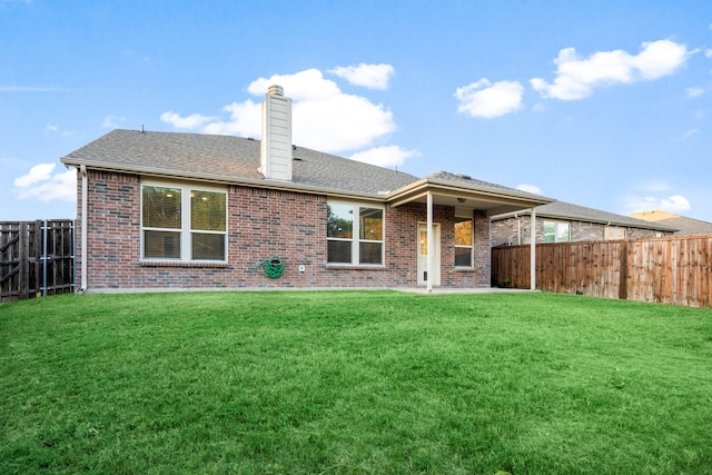 rear view of house featuring a patio and a yard