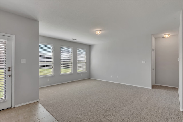 unfurnished room featuring light colored carpet and a healthy amount of sunlight