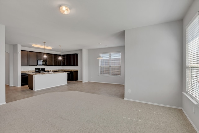 kitchen with dark brown cabinets, light colored carpet, decorative light fixtures, and a center island