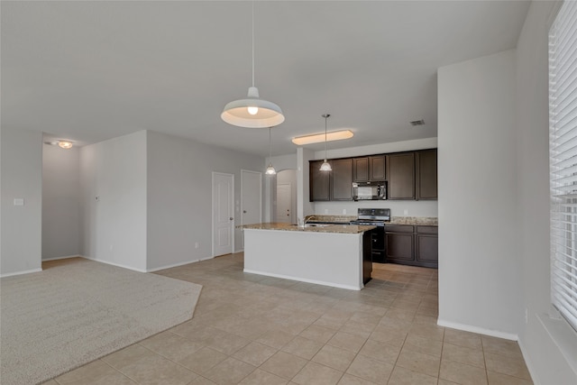 kitchen with dark brown cabinetry, black appliances, light stone counters, an island with sink, and pendant lighting