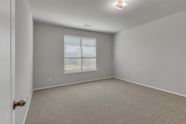 spare room featuring light colored carpet