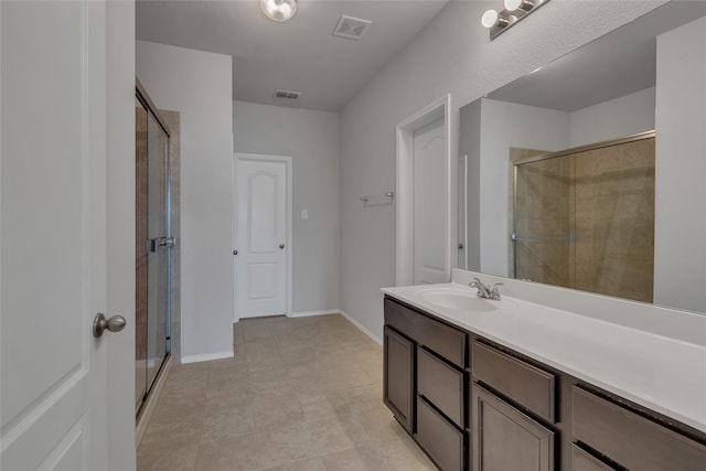 bathroom featuring vanity, tile patterned floors, and a shower with shower door