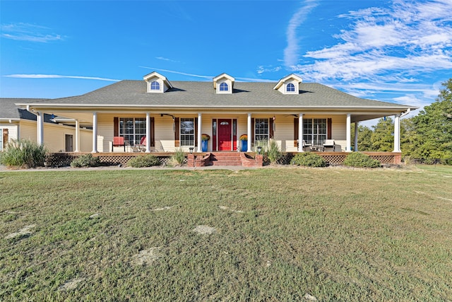 view of front of house with ceiling fan, a front yard, and covered porch