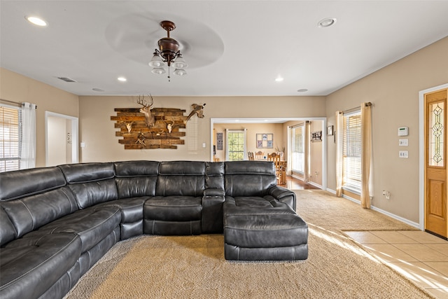 living room with a wealth of natural light, light carpet, and ceiling fan