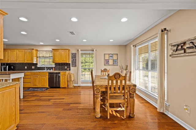 kitchen featuring dishwasher, light hardwood / wood-style floors, sink, and backsplash