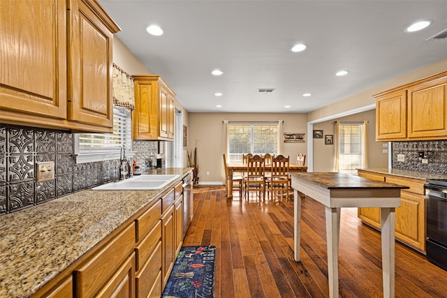 kitchen with light stone countertops, dark hardwood / wood-style floors, sink, and tasteful backsplash