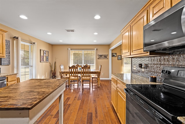 kitchen with stainless steel appliances, light hardwood / wood-style floors, plenty of natural light, and decorative backsplash