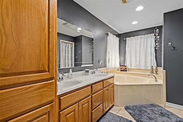 bathroom with a washtub, vanity, and tile patterned floors