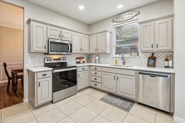 kitchen featuring gray cabinets, sink, light tile patterned flooring, and stainless steel appliances