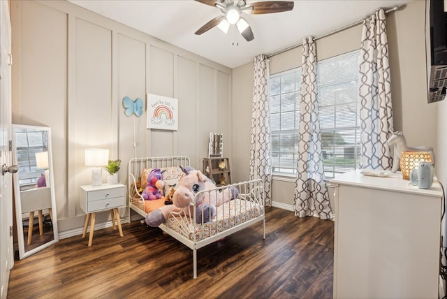 bedroom with ceiling fan, dark hardwood / wood-style flooring, and multiple windows