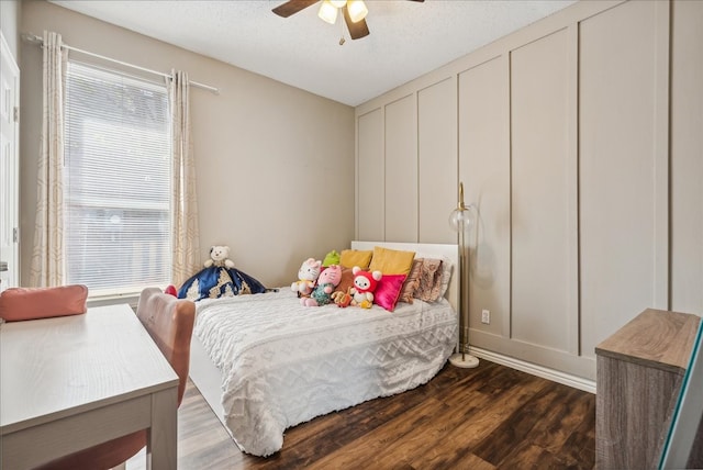 bedroom with a textured ceiling, ceiling fan, and dark hardwood / wood-style floors