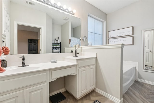 bathroom featuring vanity, wood-type flooring, and a washtub