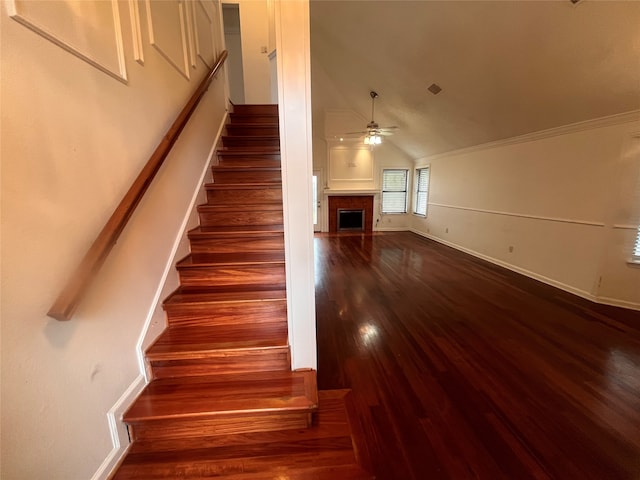 stairway featuring ornamental molding, lofted ceiling, hardwood / wood-style flooring, and ceiling fan