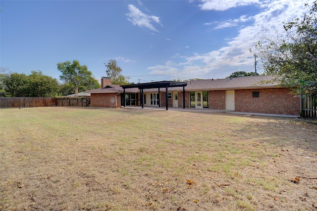 back of property featuring a patio area and a lawn