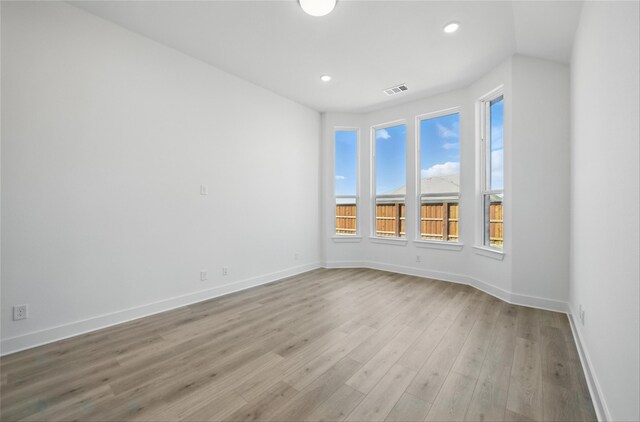 spare room with visible vents, baseboards, recessed lighting, and wood finished floors