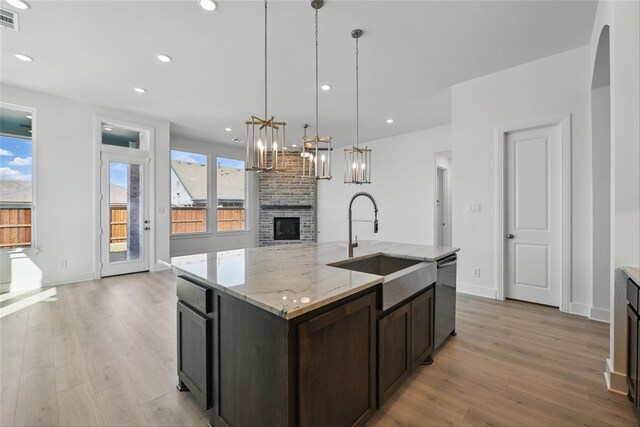 kitchen with light wood-style flooring, a sink, dishwashing machine, and recessed lighting