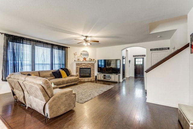 living room with ceiling fan, dark hardwood / wood-style floors, and a fireplace