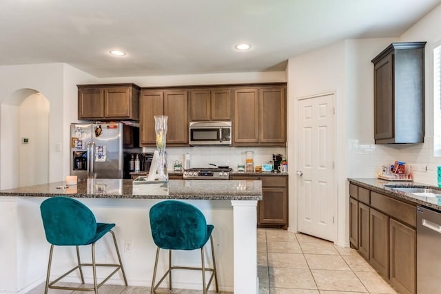 kitchen with dark stone countertops, a center island, and stainless steel appliances