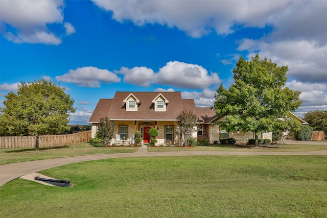 cape cod house featuring covered porch and a front yard