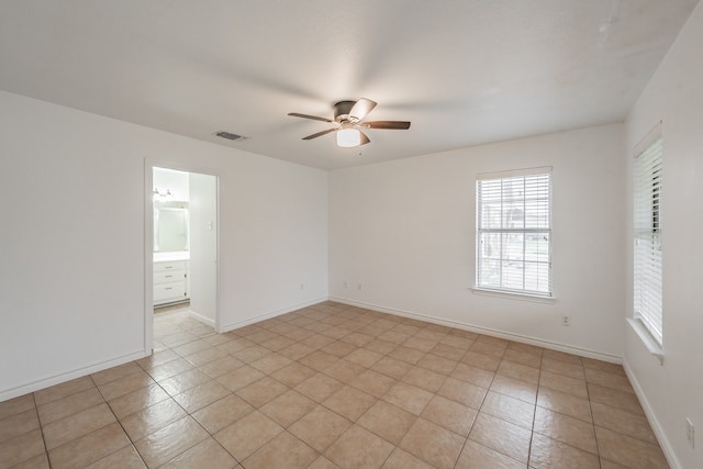 tiled spare room featuring ceiling fan