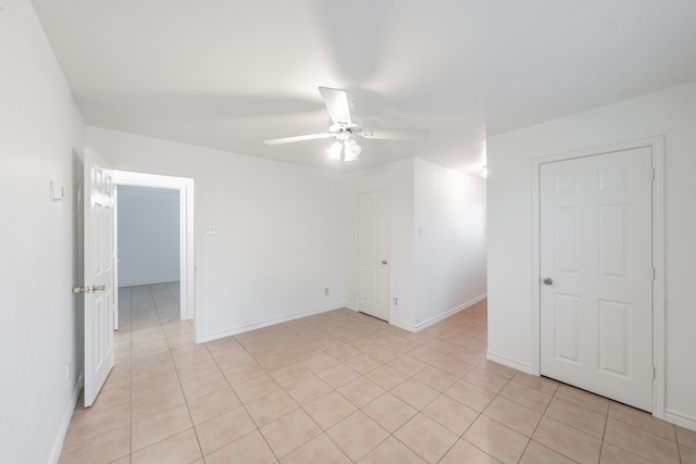 tiled spare room featuring ceiling fan