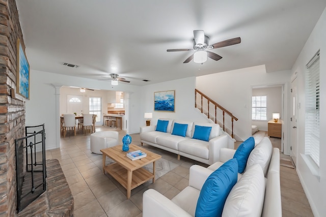 tiled living room featuring decorative columns and ceiling fan