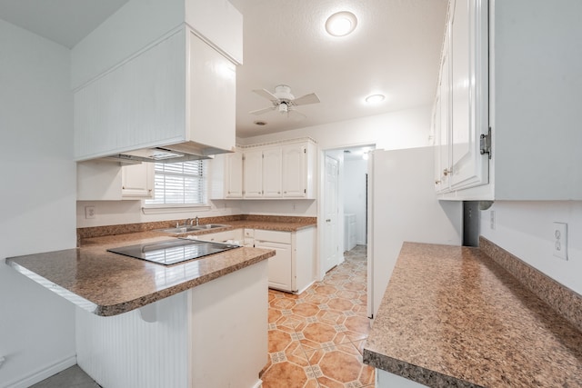 kitchen featuring white cabinetry, kitchen peninsula, black electric cooktop, and ceiling fan