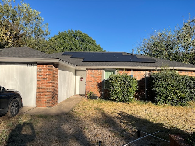 view of side of home featuring solar panels and a yard