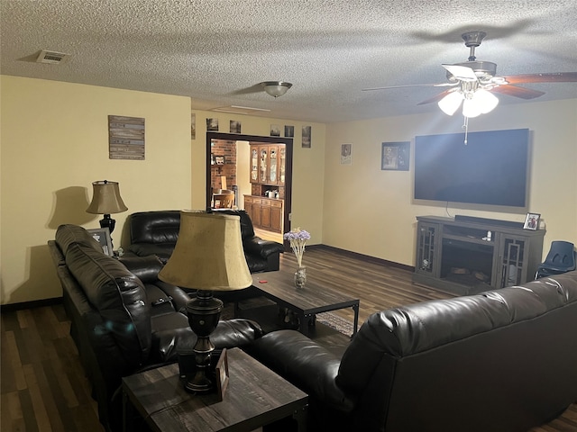 living room featuring dark hardwood / wood-style flooring, a textured ceiling, and ceiling fan