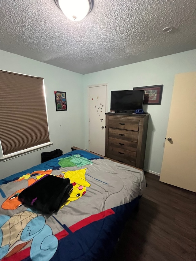 bedroom with a textured ceiling and dark hardwood / wood-style floors