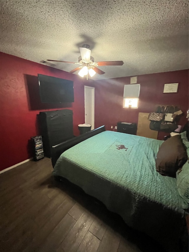 bedroom with hardwood / wood-style floors, a textured ceiling, and ceiling fan