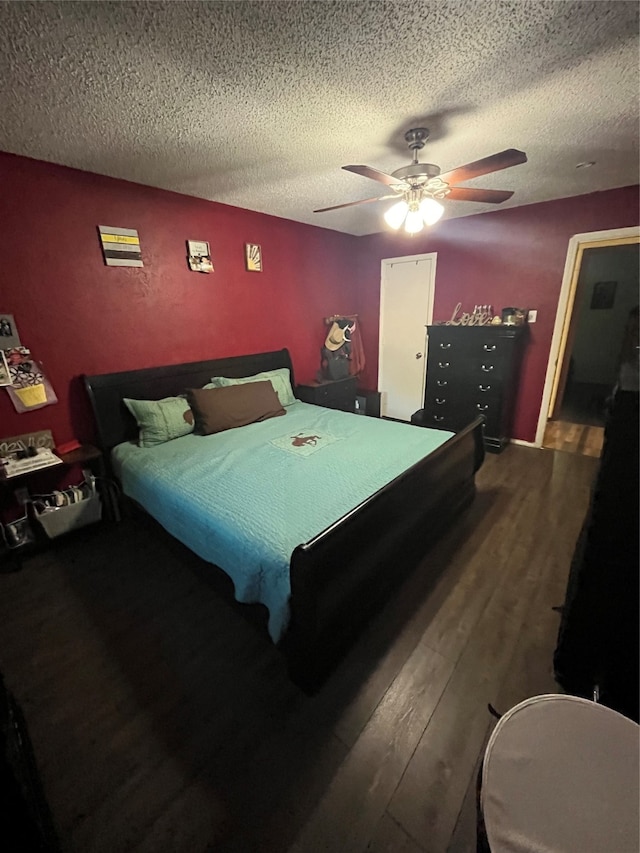 bedroom with hardwood / wood-style floors, ceiling fan, and a textured ceiling