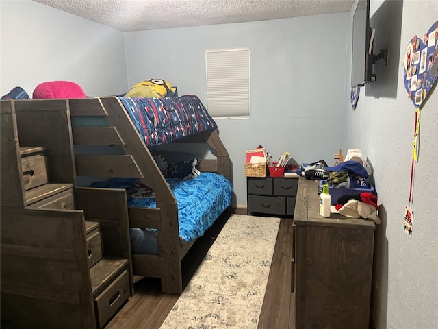 bedroom featuring dark wood-type flooring and a textured ceiling