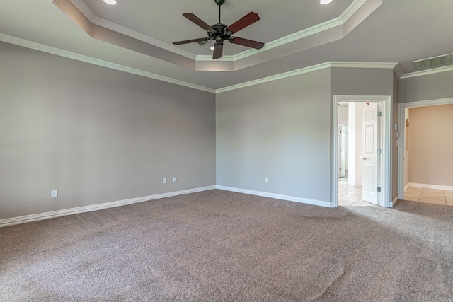 carpeted spare room featuring ceiling fan, ornamental molding, and a raised ceiling