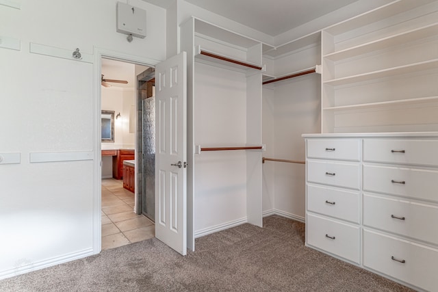 spacious closet featuring light colored carpet and ceiling fan