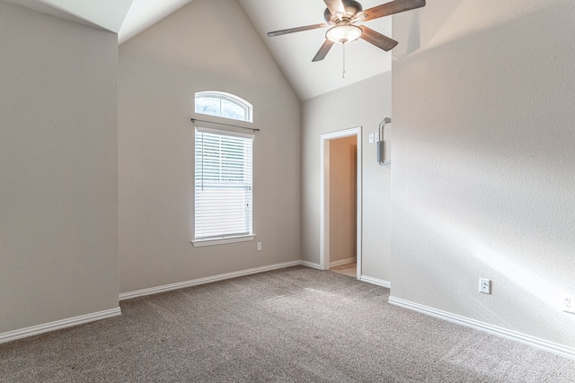 empty room with high vaulted ceiling, carpet floors, and ceiling fan