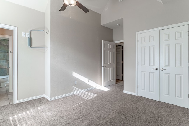 unfurnished bedroom with ensuite bathroom, ceiling fan, lofted ceiling, light colored carpet, and a closet