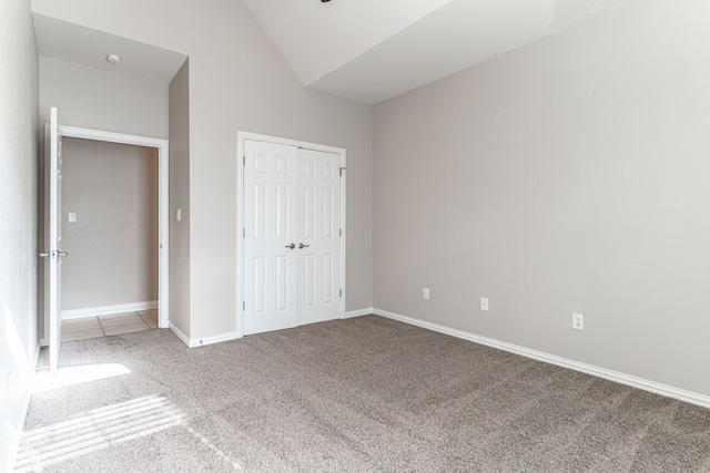 unfurnished bedroom featuring a closet, lofted ceiling, and carpet flooring