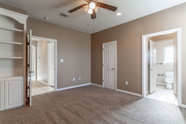 unfurnished bedroom featuring light carpet, ceiling fan, and connected bathroom