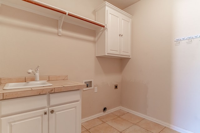 laundry room with hookup for an electric dryer, cabinets, sink, light tile patterned floors, and hookup for a washing machine