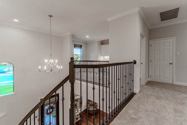 corridor with a notable chandelier, carpet flooring, and ornamental molding