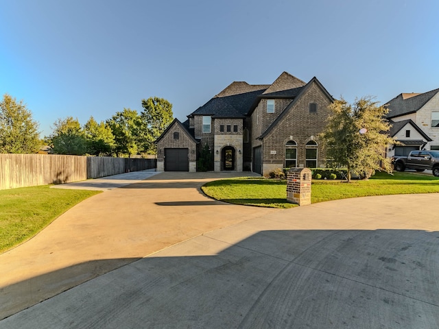 french country home featuring a garage and a front yard