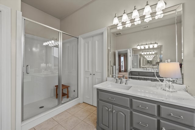 bathroom with walk in shower, vanity, and tile patterned floors