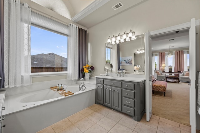 bathroom featuring a bathtub, a wealth of natural light, vanity, and tile patterned floors